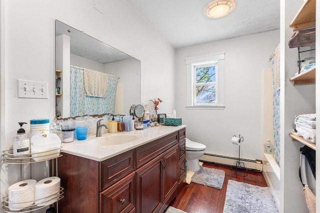 bathroom with a baseboard radiator, toilet, wood finished floors, vanity, and baseboards