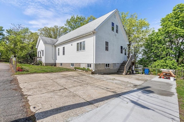 view of side of property with stairway and driveway