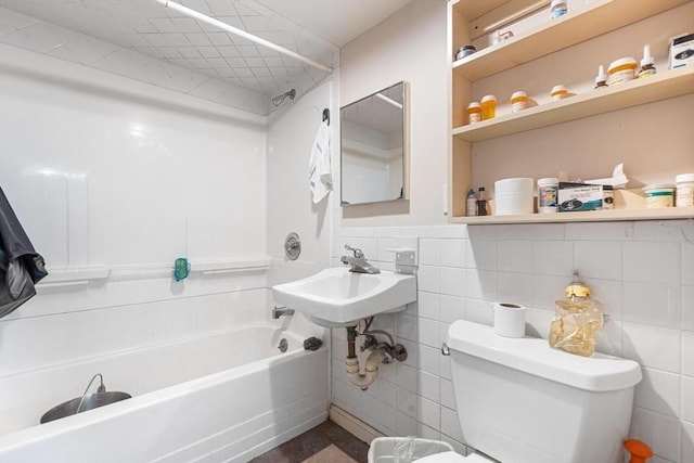 full bath featuring tile walls, toilet, bathing tub / shower combination, and a sink
