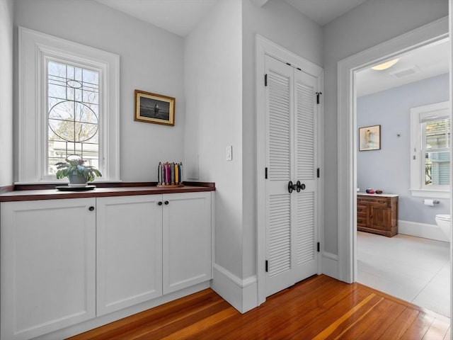 hall with baseboards and wood finished floors