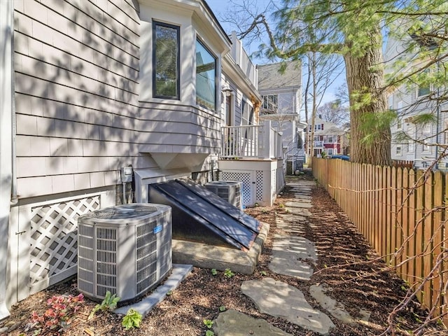 view of side of property with fence and central AC unit