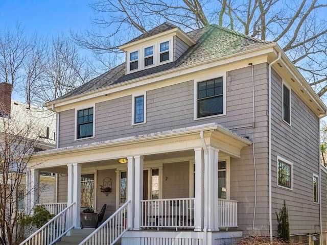 traditional style home featuring roof with shingles and covered porch
