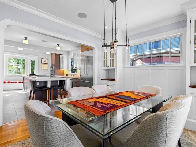 dining area with crown molding and light wood finished floors