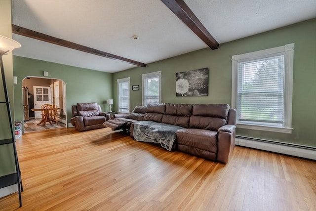 735 Hildreth St, Dracut, MA 01826 - living room with beam ceiling, arched walkways, a baseboard radiator, healthy amount of natural light, and light wood-style floors