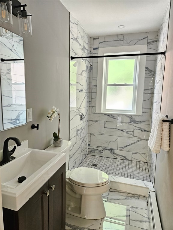 bathroom with vanity, toilet, a baseboard heating unit, and tiled shower