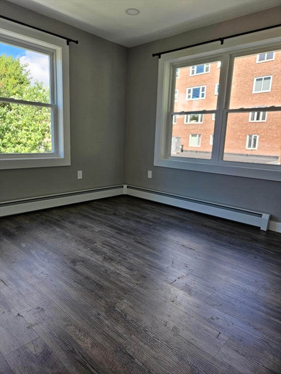 spare room featuring dark hardwood / wood-style floors and a baseboard radiator