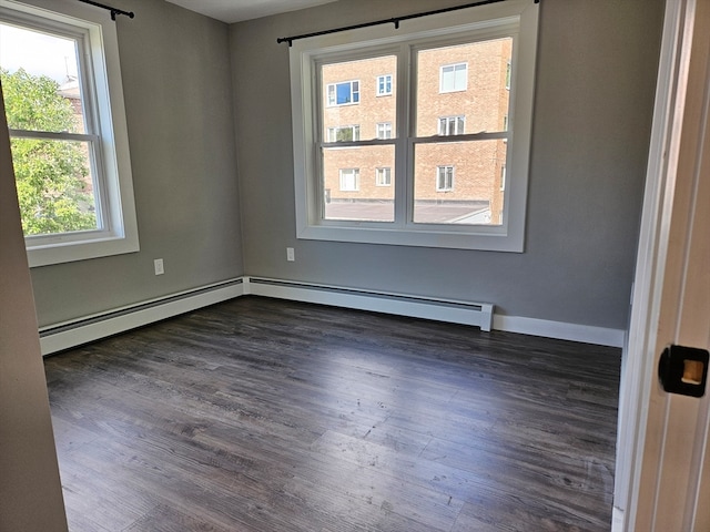 spare room featuring a baseboard radiator and dark hardwood / wood-style floors