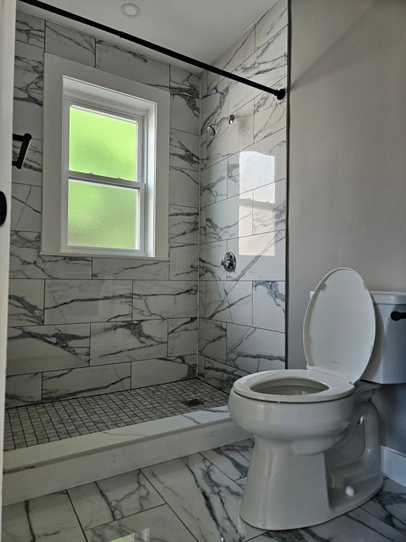 bathroom featuring toilet and a tile shower