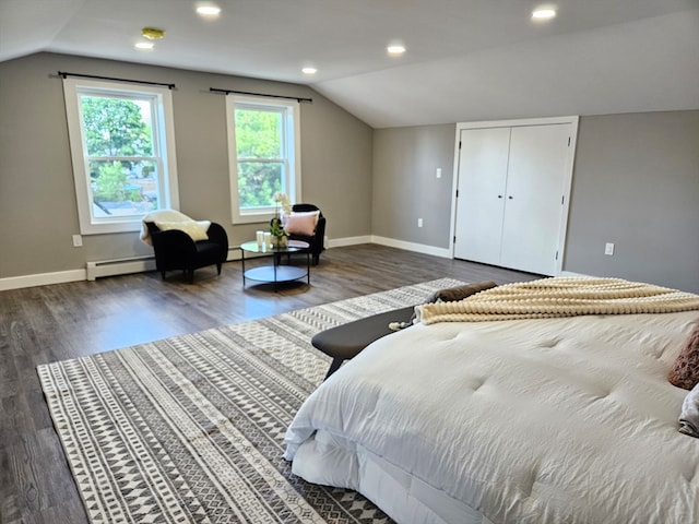 bedroom featuring dark wood-type flooring, a closet, vaulted ceiling, and baseboard heating