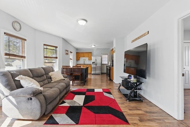 living area featuring baseboards and light wood-style flooring