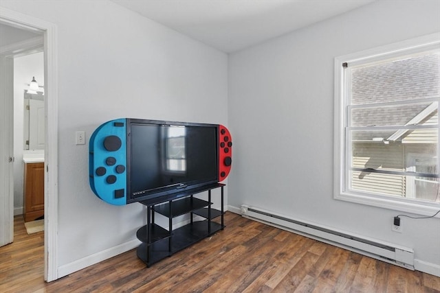 miscellaneous room featuring plenty of natural light, a baseboard radiator, baseboards, and wood finished floors