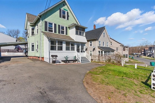 view of front of home with a residential view and a shingled roof
