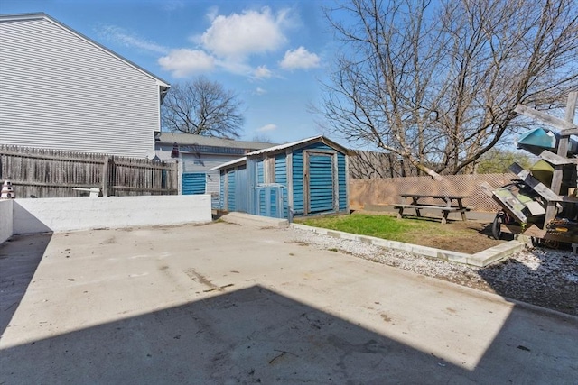 exterior space featuring a fenced backyard, a shed, and an outbuilding