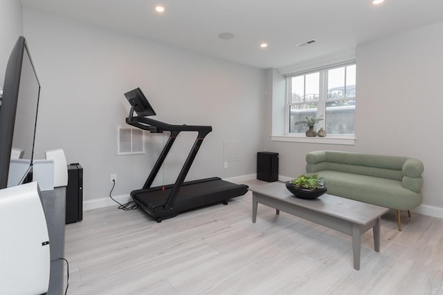 workout area with light hardwood / wood-style flooring