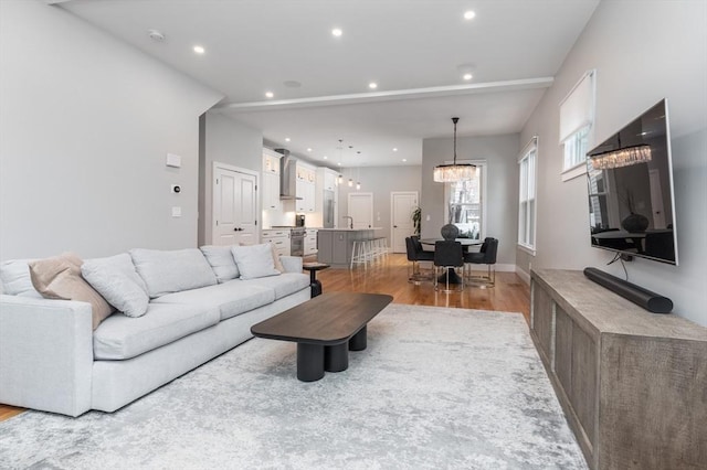 living room with a chandelier and light wood-type flooring