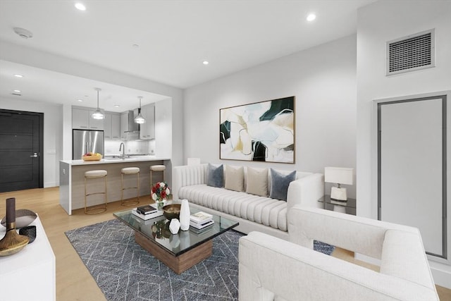 living room featuring recessed lighting, visible vents, and light wood-style floors