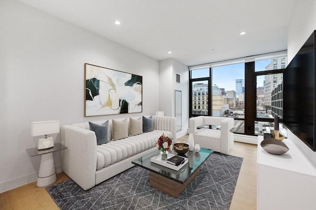 living room featuring recessed lighting, baseboards, and light wood finished floors