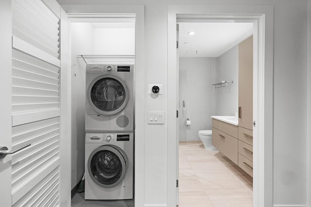 clothes washing area featuring laundry area and stacked washer / drying machine