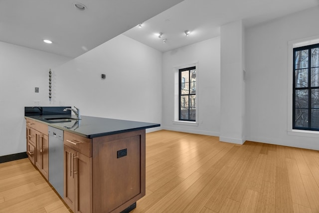 kitchen featuring light wood-type flooring, kitchen peninsula, sink, and dishwasher