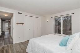 bedroom with a closet, visible vents, and wood finished floors