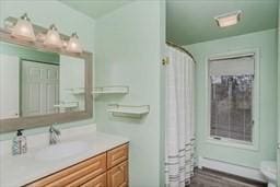 full bath with toilet, curtained shower, and vanity