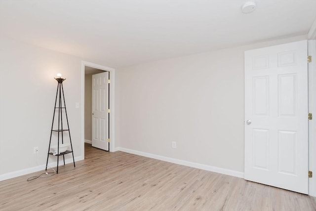 unfurnished room with light wood finished floors and baseboards