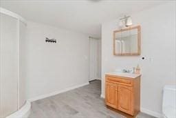 bathroom featuring wood finished floors, vanity, and baseboards