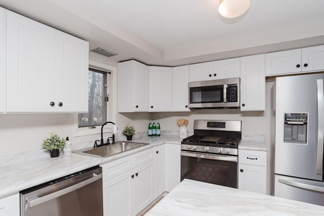 kitchen featuring stainless steel appliances, white cabinets, and a sink