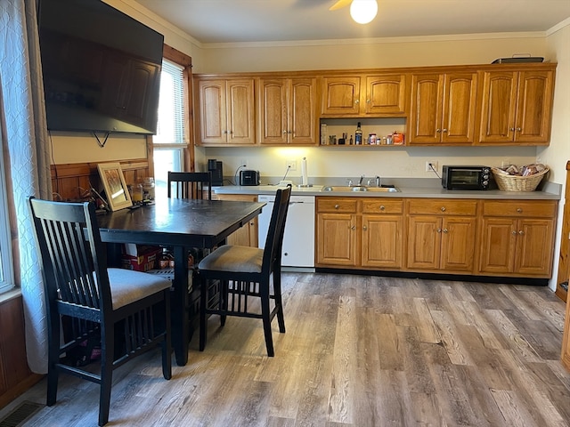 kitchen featuring crown molding, sink, white dishwasher, and wood-type flooring