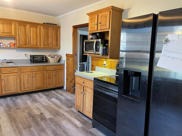 kitchen featuring sink, wood-type flooring, crown molding, and appliances with stainless steel finishes