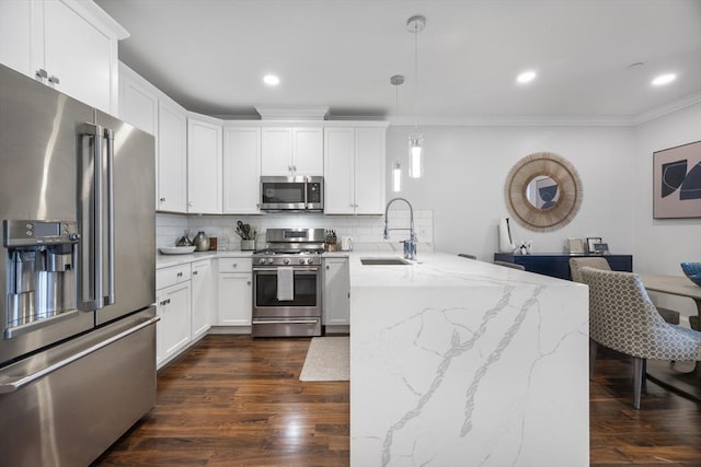 kitchen with sink, white cabinetry, appliances with stainless steel finishes, pendant lighting, and light stone countertops