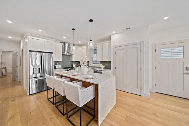 59 Falcon St Unit 1, Boston, MA 02128 - kitchen with stainless steel appliances, wall chimney exhaust hood, backsplash, light wood-style floors, and recessed lighting