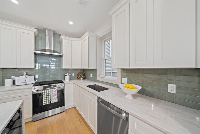 59 Falcon St Unit 1, Boston, MA 02128 - kitchen featuring stainless steel appliances, wall chimney exhaust hood, backsplash, white cabinets, and light stone countertops
