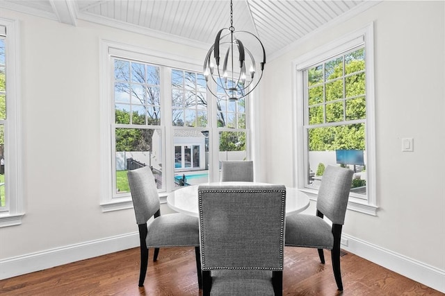 dining area featuring baseboards, ornamental molding, wood finished floors, and a notable chandelier