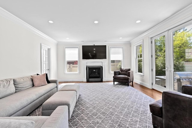 living room featuring crown molding, recessed lighting, wood finished floors, and a healthy amount of sunlight