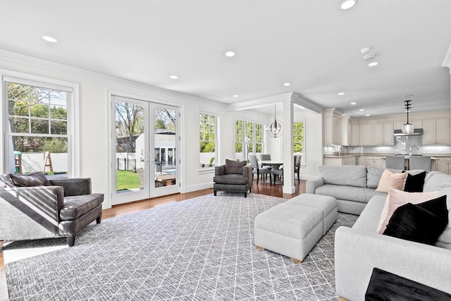 living room with recessed lighting, ornamental molding, light wood-style flooring, and french doors