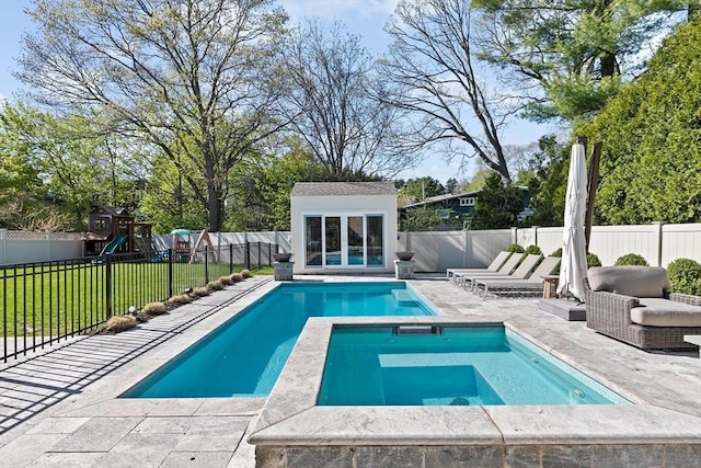 view of pool with a lawn, an outbuilding, a patio area, a storage structure, and a fenced backyard