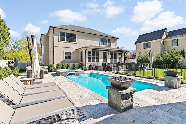 back of property with a patio, a pool with connected hot tub, a fenced backyard, and stucco siding
