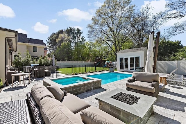 view of swimming pool with an outbuilding, a patio area, a storage structure, and an outdoor living space with a fire pit