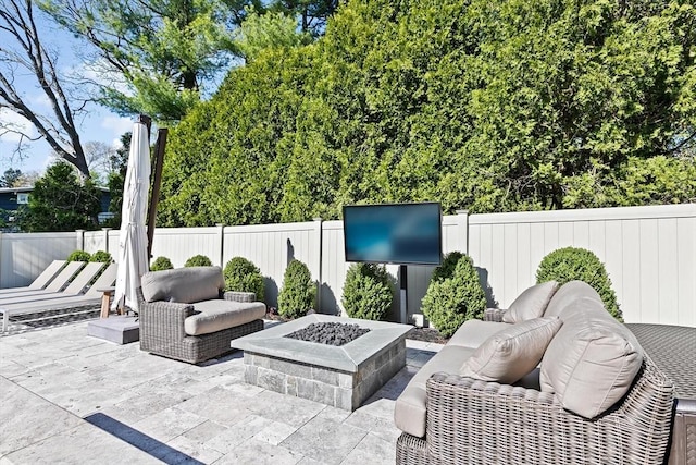 view of patio / terrace with a fenced backyard and an outdoor living space with a fire pit