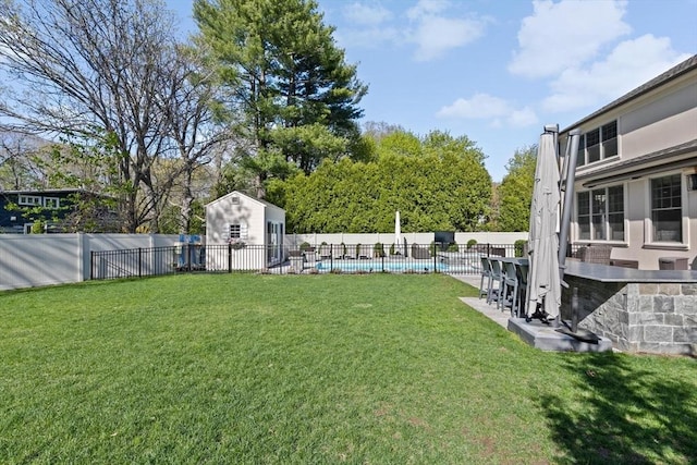 view of yard with a fenced in pool, a fenced backyard, and an outdoor structure