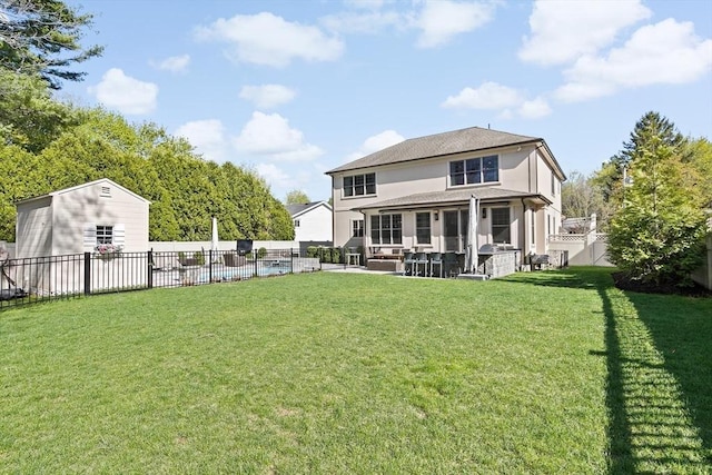 rear view of house with a fenced backyard, a patio area, and a yard