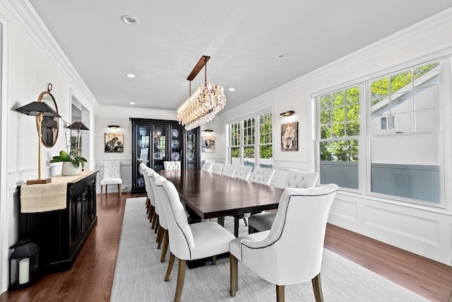 dining space with ornamental molding, a decorative wall, and a notable chandelier