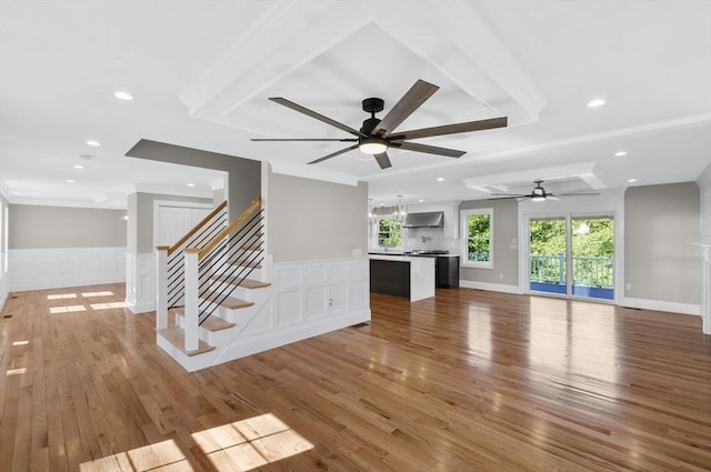 unfurnished living room with hardwood / wood-style flooring, ceiling fan, and crown molding