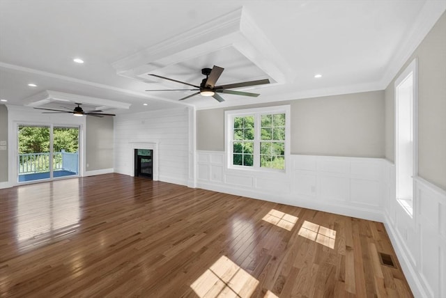 unfurnished living room featuring ornamental molding, a large fireplace, and hardwood / wood-style floors