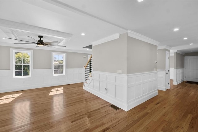 empty room with wood-type flooring, ornamental molding, and ceiling fan