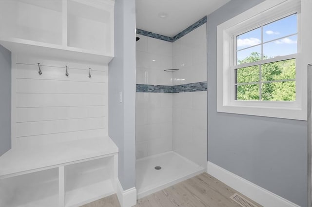 bathroom featuring tiled shower and wood-type flooring