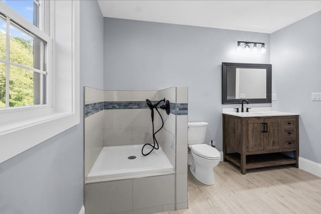 bathroom featuring vanity, wood-type flooring, toilet, and walk in shower