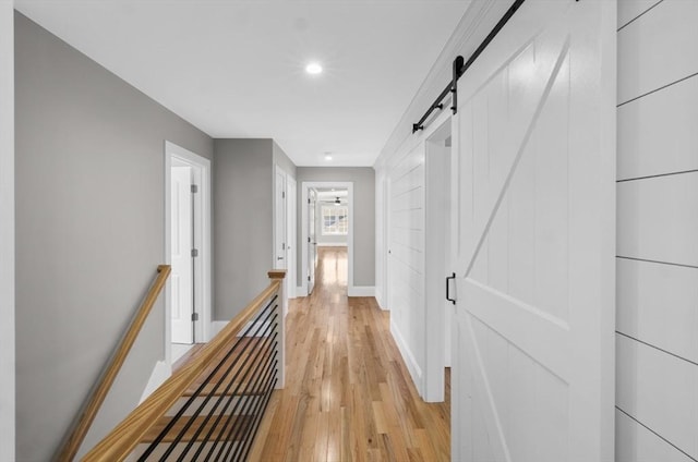 corridor featuring a barn door and light hardwood / wood-style floors