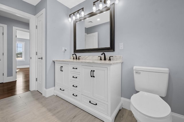 bathroom featuring vanity, toilet, and hardwood / wood-style floors